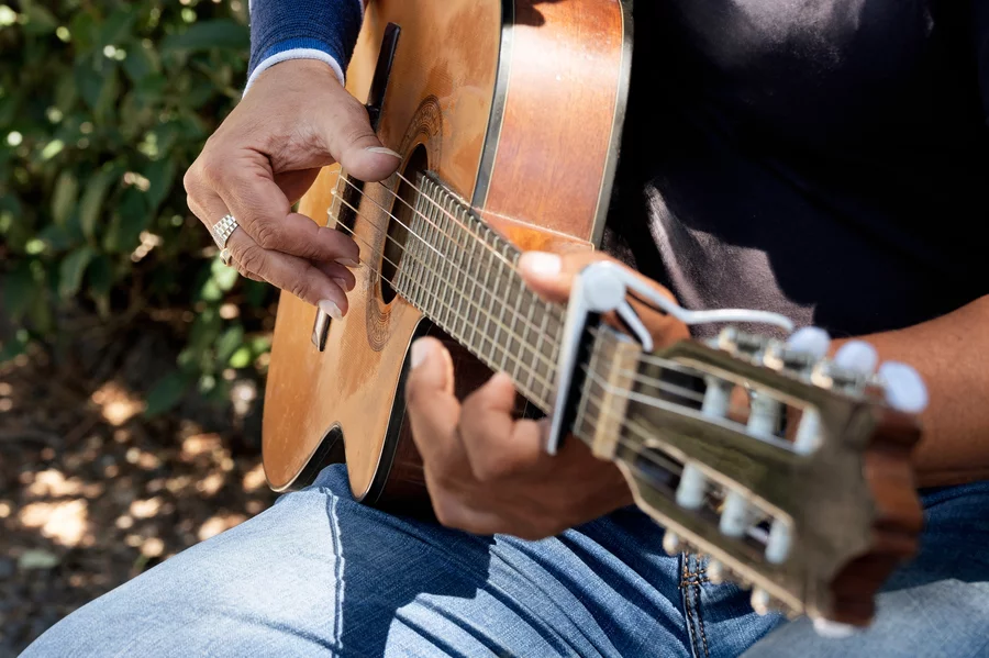 A close-up on a person’s hands playing the guitar